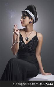 Young woman in evening gown smoking