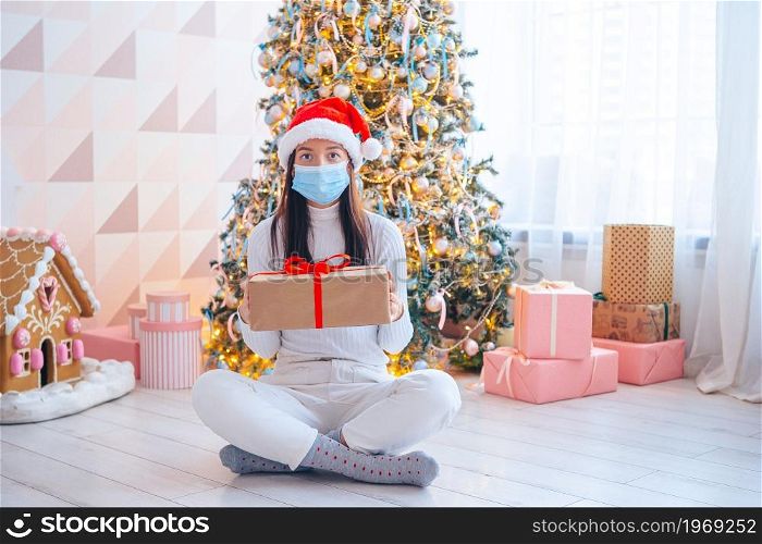 Young woman in facemask with gifts on Christmas. Young woman in mask holding christmas present
