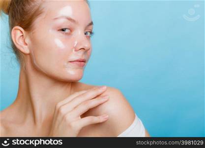 Young woman in facial peel off mask. Peeling. Beauty and skin care. Studio shot on blue background. Woman in facial peel off mask.