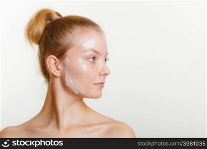 Young woman in facial peel off mask. Peeling. Beauty and skin care. Studio shot on gray. Woman in facial peel off mask.