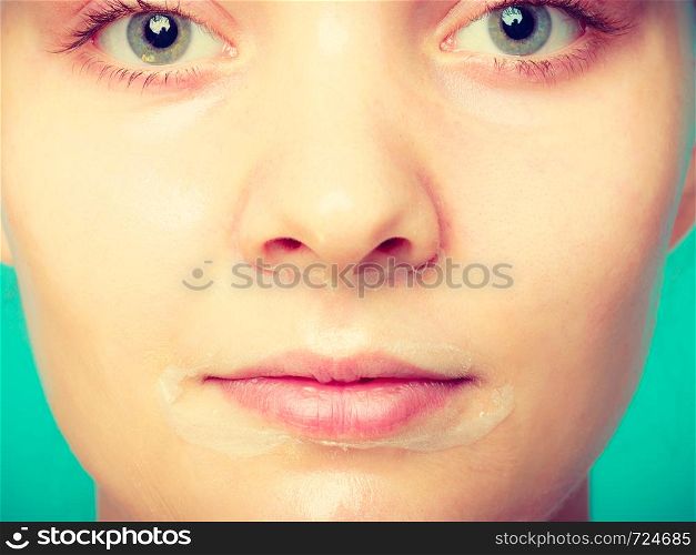 Young woman in facial peel off mask. Peeling. Beauty and skin care. Studio shot on green. Woman in facial peel off mask.