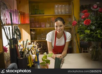Young woman in flower shop with rose arrangement