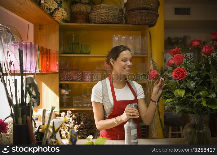 Young woman in flower shop with rose arrangement