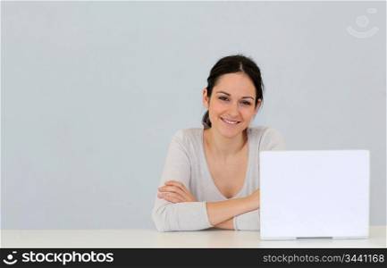 Young woman in front of laptop computer isolated