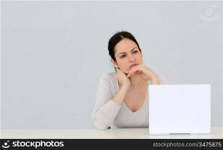 Young woman in front of laptop computer isolated