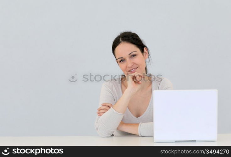 Young woman in front of laptop computer isolated