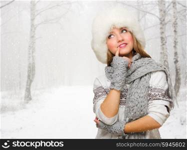 Young woman in fur hat at snowy forest