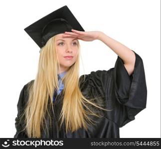 Young woman in graduation gown looking into distance
