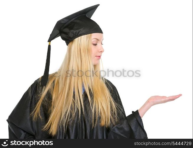 Young woman in graduation gown presenting something on empty palm