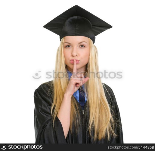 Young woman in graduation gown showing shh gesture