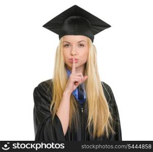 Young woman in graduation gown showing shh gesture