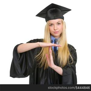Young woman in graduation gown showing stop gesture