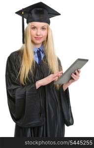 Young woman in graduation gown using tablet pc