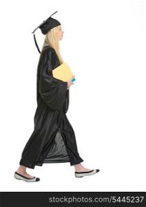 Young woman in graduation gown with books going sideways