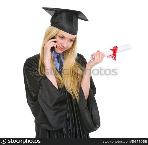 Young woman in graduation gown with diploma talking mobile phone