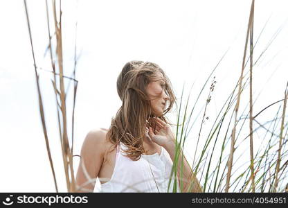 Young woman in grass, looking away