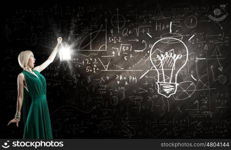 Young woman in green dress with lantern in darkness. Bright ideas