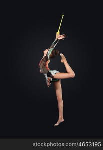 Young woman in gymnast suit posing. Young cute woman in gymnast suit show athletic skill on black background