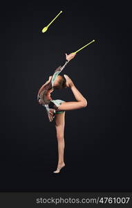 Young woman in gymnast suit posing. Young cute woman in gymnast suit show athletic skill on black background