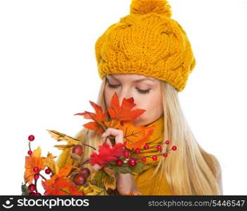 Young woman in hat and scarf smelling autumn bouquet