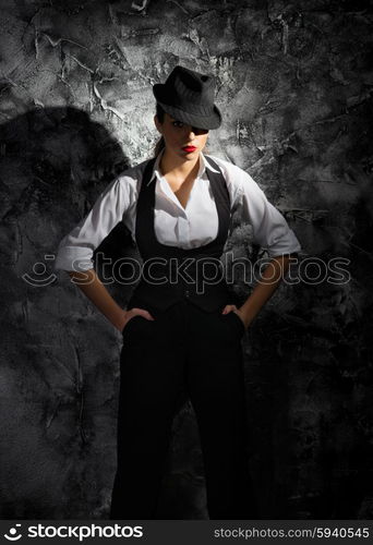 Young woman in hat on grey wall