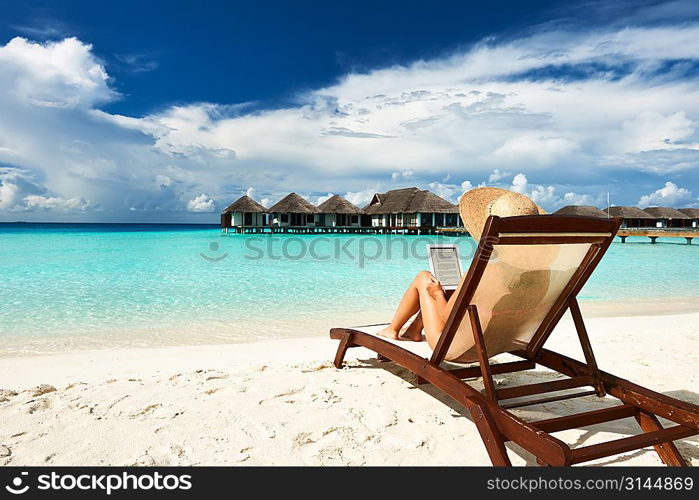 Young woman in hat with tablet pc at the beach