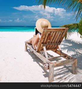 Young woman in hat with tablet pc at the beach