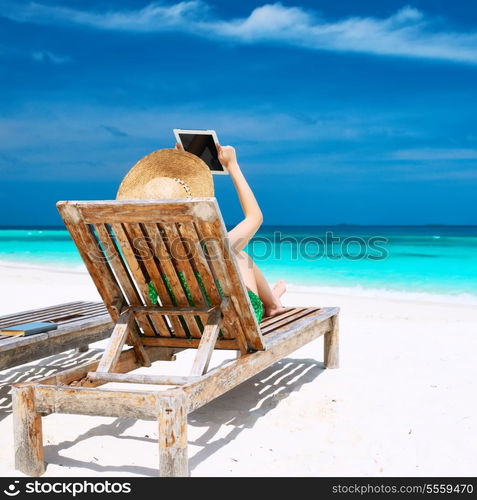 Young woman in hat with tablet pc at the beach