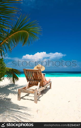 Young woman in hat with tablet pc at the beach