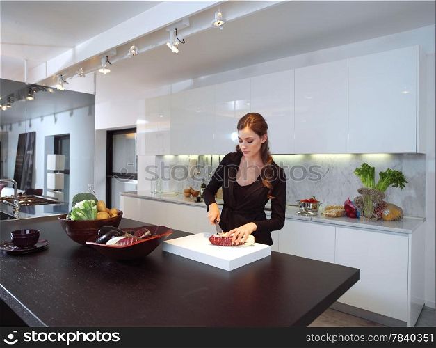 Young woman in her kitchen cutting ingredients