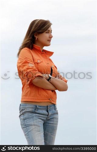 young woman in jeans and jacket, profile. girl in orange jacket