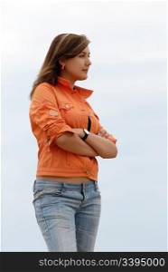 young woman in jeans and jacket, profile. girl in orange jacket