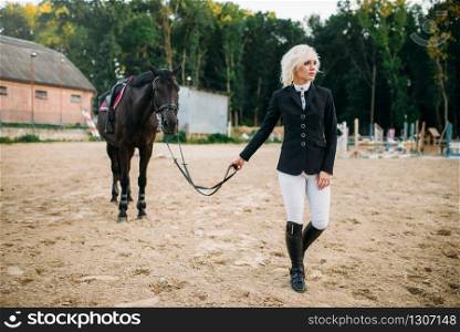 Young woman in jockey uniform and horse, horseback riding. Brown stallion, leisure with animal, equestrian sport