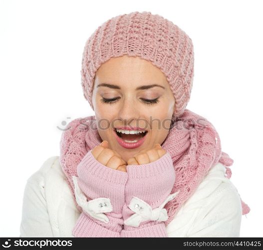 Young woman in knit scarf, hat and mittens breathing on hands