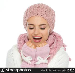 Young woman in knit scarf, hat and mittens breathing on hands
