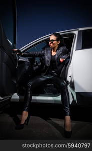 Young woman in leather clothes with car