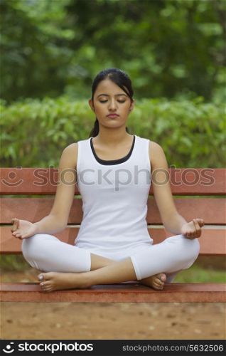 Young woman in lotus position meditating