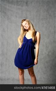 young woman in navy blue dress studio shot on gray