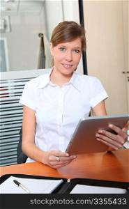 Young woman in office iwith electronic pad