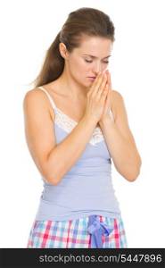 Young woman in pajamas praying before sleep
