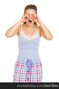 Young woman in pajamas rubbing eyes