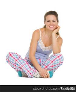 Young woman in pajamas sitting on floor isolated on white