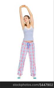 Young woman in pajamas stretching after sleep