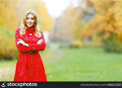 Young woman in red coat walking in autumn park. Young woman in autumn park