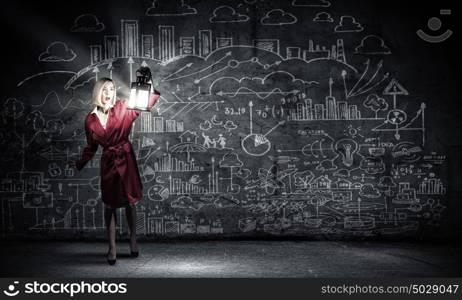 Young woman in red coat with lantern lost in darkness. Searching for inspiration