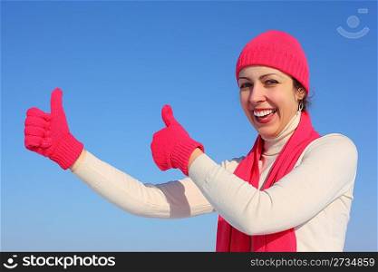 Young woman in red gloves shows gesture ok