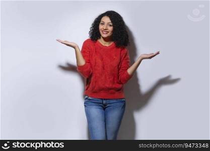 Young woman in red sweater posing with raising her arms