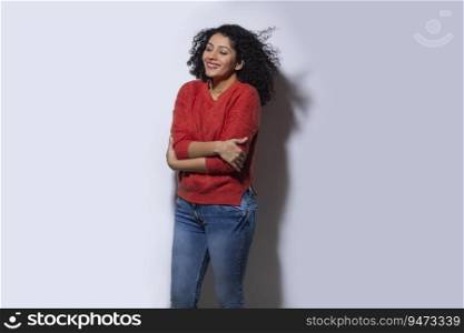Young woman in red sweater standing with crossed hands