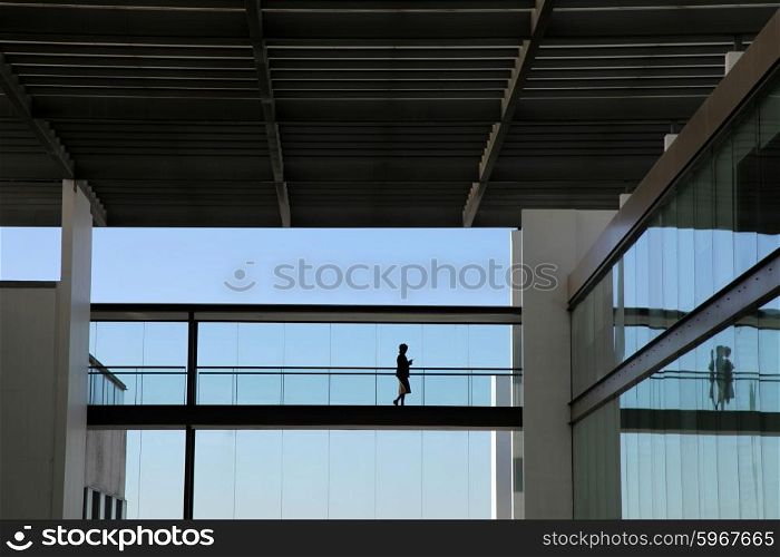 young woman in silhouette walking in the modern office building