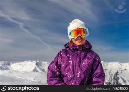 Young woman in ski goggles outdoors with French Alps covered with snow at background. Meribel, France